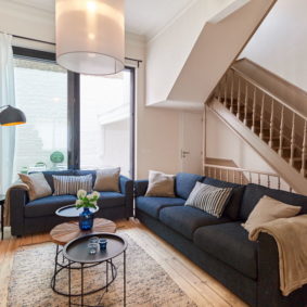 high-end living space with stylish and comfortable blue sofas in a fully renovated shared house for expats in Ixelles