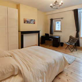 furnished bedroom with design desk and wooden floor for a shrehomer in the cardinal house