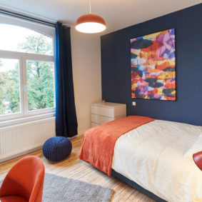 design room in the orange style with a double bed in a cohousing in Brussels