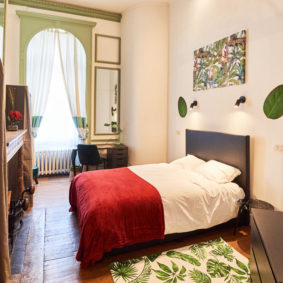 room with double bed designed with style and with a private shower in a coliving space for expats