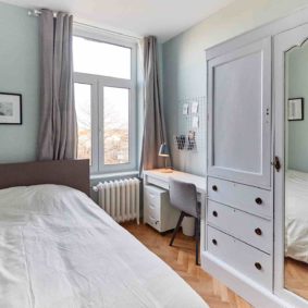 room with a comfortable double bed and private shower in a coliving in Brussels close to different points of interest