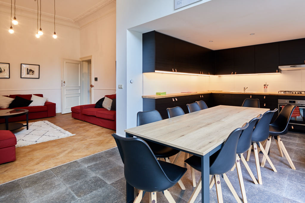 fully equipped kitchen designed in black with a big dining table in a shared house for expats in Brussels