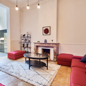 well designed living room with stylish red sofas in a shared house for expats in Brussels