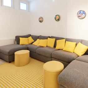 cosy chilling room with comfortable grey sofas in a shared house for 9 young professionals close to the European Commission