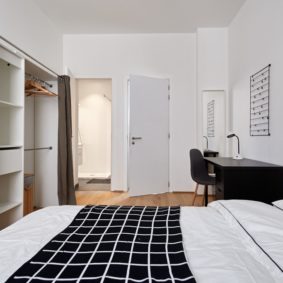 room with a comfortable double bed and private shower in a coliving in Brussels close to different points of interest