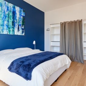 room with a comfortable double bed decorated in the blue style with a private shower in a shared house for expats in Brussels