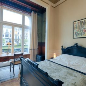 room with a comfortable double bed and private shower in a coliving in Brussels close to different points of interest