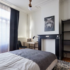 room with a comfortable double bed and private shower in a coliving in Brussels close to different points of interest