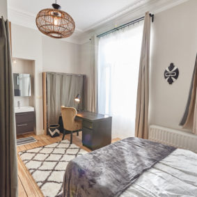 room including a double bed and a private shower in a co-living house for expats in Brussels