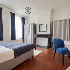 room decorated in the blue style comprising a private shower in a coliving