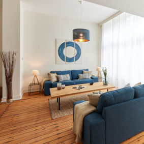 well designed living room with stylish blue sofass in a shared house for young professionals in Brussels