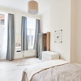 sunny room with a comfortable double bed in a coliving house for young professionals in Brussels