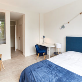 sunny room with a comfortable double bed in a co housing building for young professionals in Brussels