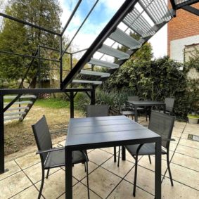 Furnished terrace with chairs and tables and a BBQ to enjoy with your housemates in a spacious garden in a shared house in Brussels