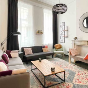 Cosy living room with large windows in a design coliving house in Brussels