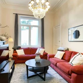 Well-decorated living room in coliving with comfortable and modern red sofa